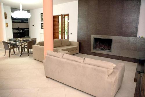 a living room with a couch and a fireplace at Charming villa in Alvignano with private pool in Alvignano