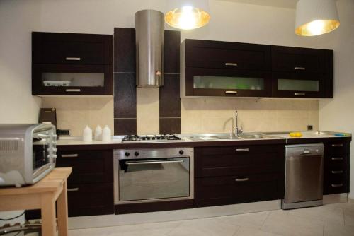 a kitchen with black cabinets and a stainless steel oven at Charming villa in Alvignano with private pool in Alvignano