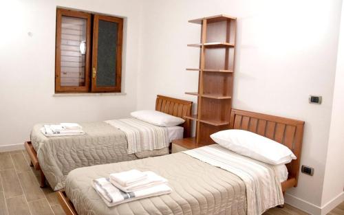 two beds in a room with towels on them at Charming villa in Alvignano with private pool in Alvignano
