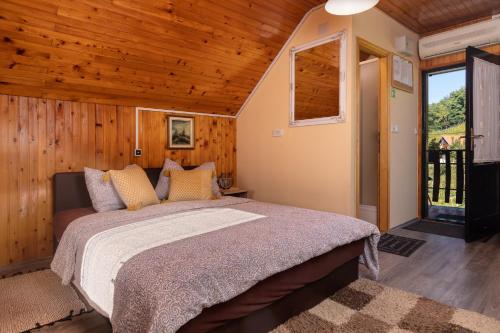ein Schlafzimmer mit einem Bett in einem Zimmer mit Holzwänden in der Unterkunft Studio apartman Vidikovac in Pregrada
