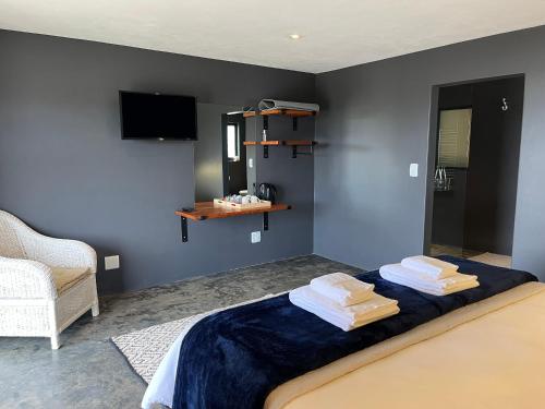a bedroom with a bed with towels on it at The Capri Green in Knysna