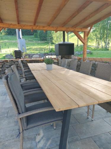 a wooden table and chairs under a pavilion at Chalupa Bezvětří in Malá Morávka