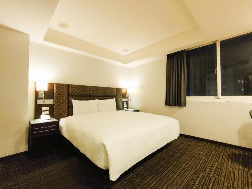 台北市にあるHub Hotel Banqiao Branchの大きなベッドと窓が備わるホテルルームです。