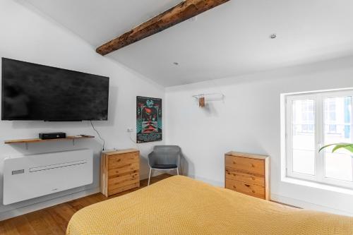 1 dormitorio con 1 cama y TV de pantalla plana en Singulary House-Loft with AC Downtown - Dodo et Tartine, en Hyères