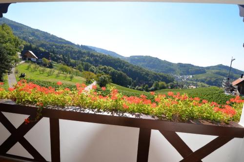 a balcony with flowers and a view of a valley at RelaxHotel Tannenhof in Sasbachwalden