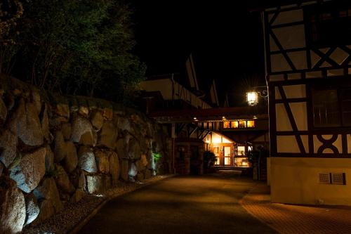 a stone wall next to a building at night at RelaxHotel Tannenhof in Sasbachwalden
