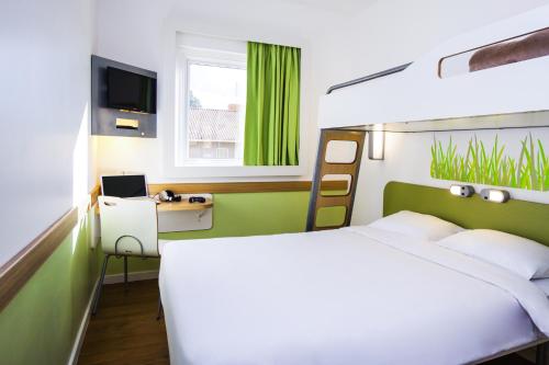 Postel nebo postele na pokoji v ubytování Hotel Ibis Budget Lyon Eurexpo -