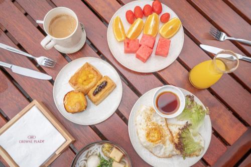 einen Tisch mit drei Tellern Frühstückslebensmittel und Kaffee in der Unterkunft Crowne Plaza Quanzhou Riverview, an IHG Hotel in Quanzhou