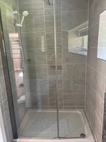 a shower with a glass door in a bathroom at Brighouse Studio - Pet Friendly! - Free Parking in Brighouse