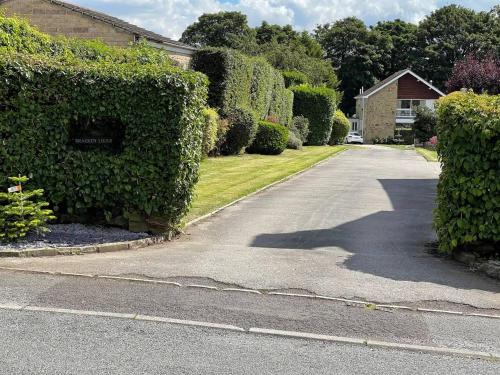 a driveway in a house with a hedge at Brighouse Studio - Pet Friendly! - Free Parking in Brighouse