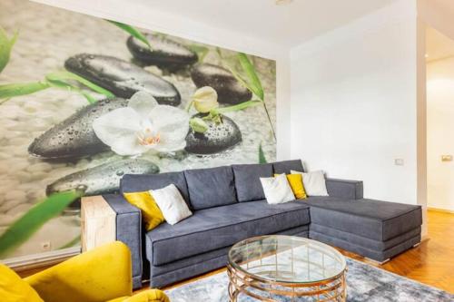 a living room with a blue couch and a painting at Apartment Artist in Belgrade