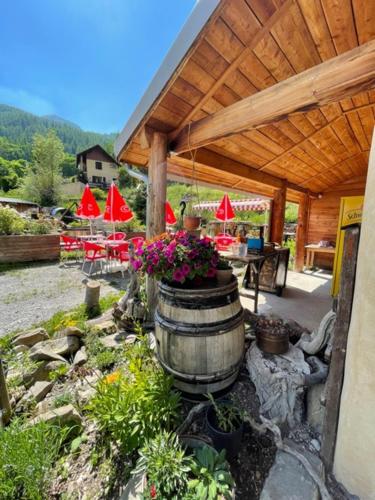 an outdoor patio with a barrel and tables and chairs at Gîte les 3 cols in Réallon