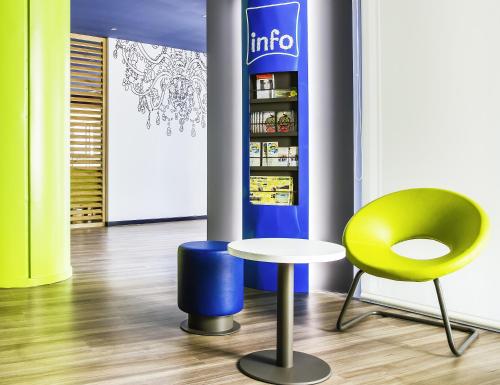 a room with a table and a chair and a refrigerator at Hotel Ibis Budget Lyon Eurexpo - in Chassieu