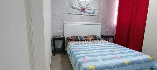a bedroom with a bed and a red curtain at Short Term Apartment Tel Aviv Bat Yam 413 in Bat Yam