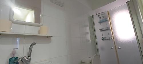 een badkamer met een douche, een wastafel en een spiegel bij Short Term Apartment Tel Aviv Bat Yam 413 in Bat Yam