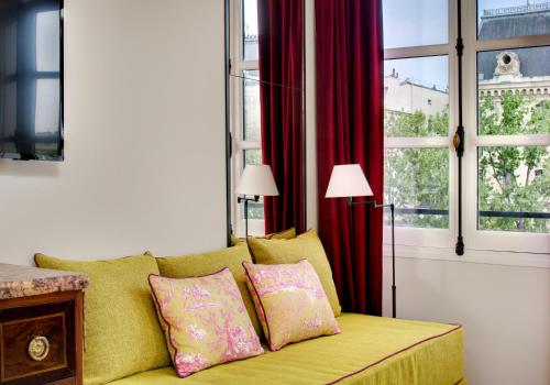a living room with a yellow couch and a window at Les Rives de Notre-Dame in Paris