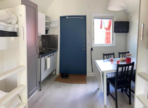a small kitchen with a table and a blue door at Dragsö Camping & Stugby in Karlskrona