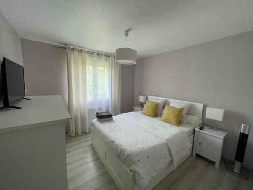 Dormitorio blanco con cama con almohadas amarillas en Maison tout confort en Touraine 4 chambres, en Fondettes