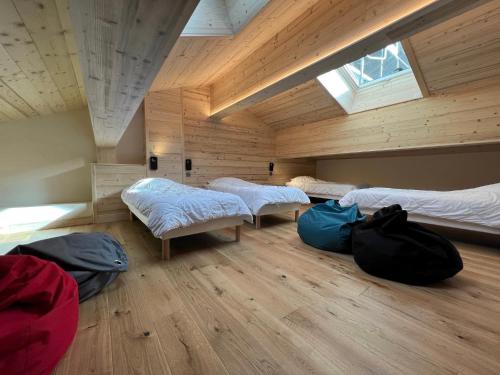 um quarto com três camas e sacos no chão em OURS POLAIRE bel appartement village et pistes em La Clusaz