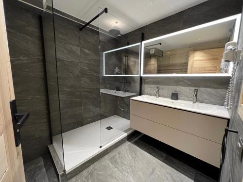 uma casa de banho com um lavatório e um chuveiro em OURS POLAIRE bel appartement village et pistes em La Clusaz