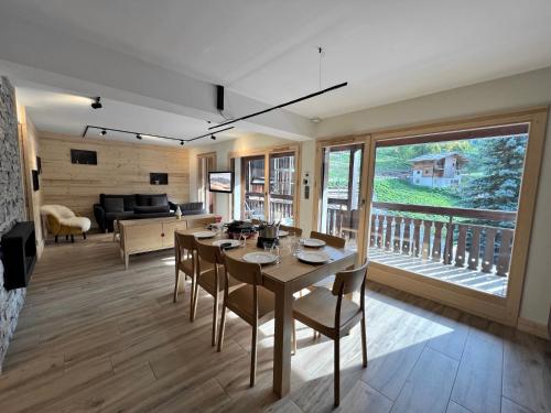 un salon avec une table, des chaises et un canapé dans l'établissement OURS POLAIRE bel appartement village et pistes, à La Clusaz