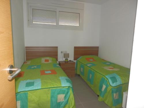 RoldánにあるApartment La Isla Terrazas de la Torreのベッド2台が隣同士に設置された部屋です。