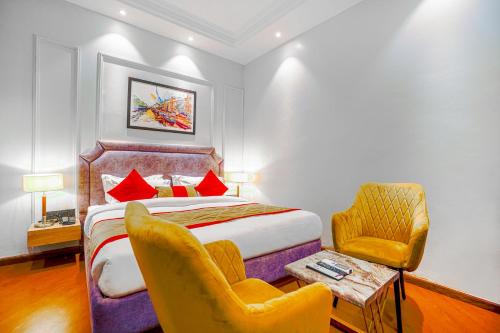 a hotel room with a bed and two chairs at Hotel Grand Cabbana By Levelup Hotels in Amritsar