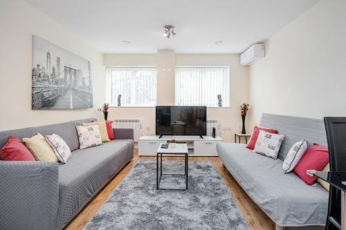 sala de estar con 2 sofás y TV en MPL Apartments - Queens Broadway F4 en Watford