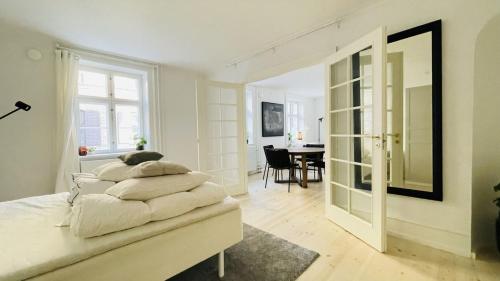 a white bedroom with a bed and a dining room at ApartmentInCopenhagen Apartment 1514 in Copenhagen
