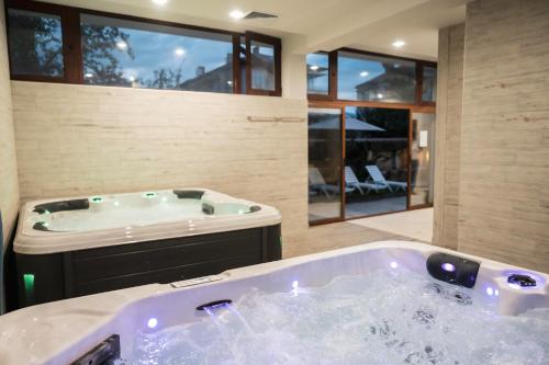 a jacuzzi tub in a large room with at Хотел Сидни in Banya