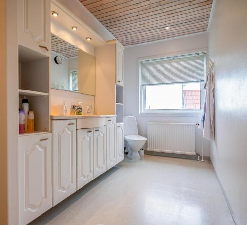 La salle de bains blanche est pourvue de toilettes et d'une fenêtre. dans l'établissement Marna Guesthouse doubleroom nr.2, à Tórshavn