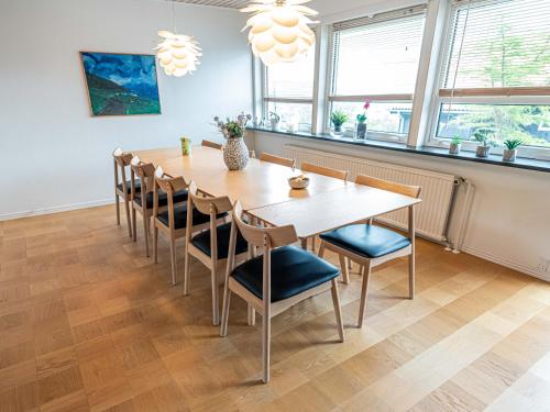 uma sala de jantar com uma mesa de madeira e cadeiras em Marna Guesthouse doubleroom nr.2 em Tórshavn