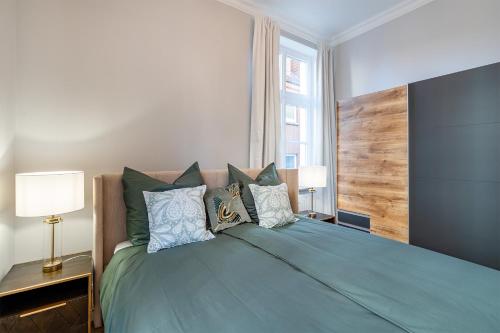 een slaapkamer met een groot groen bed met kussens bij Apartment Villa Anna - Wohnung mit Stellplatz in Emden