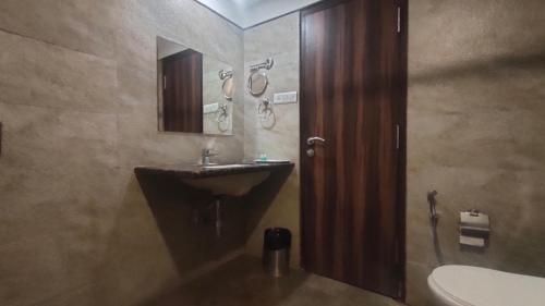 a bathroom with a sink and a mirror at Hotel Sach Regency in Anand