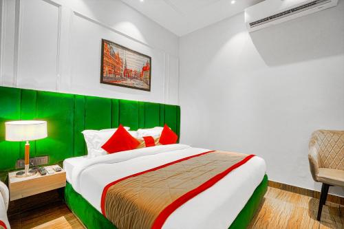 a bedroom with a large bed with a green headboard at Hotel Grand Cabbana By Levelup Hotels in Amritsar