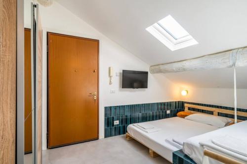ein Schlafzimmer mit einem Bett und einem TV an der Wand in der Unterkunft Easylife - Grazioso monolocale in zona Buenos Aires in Mailand