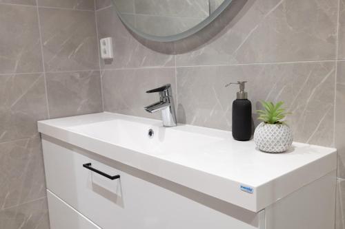 a bathroom with a sink with a soap dispenser on it at 2ndhomes Luxury 3 BR Brand New 106 m2 Apartment with Spa in Helsinki Center in Helsinki