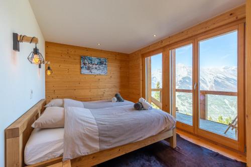 a bedroom with a bed and a large window at Ciel Etoilé - Magnifique Chalet, 14 personnes - vue incroyable in Nendaz