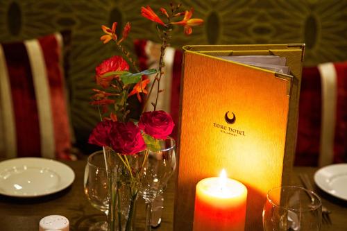 a candle and vases with flowers on a table at Torc Hotel in Killarney
