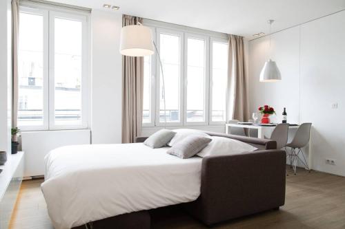 パリにあるArc de Triomphe Apartmentの白いベッドルーム(大型ベッド1台、窓付)