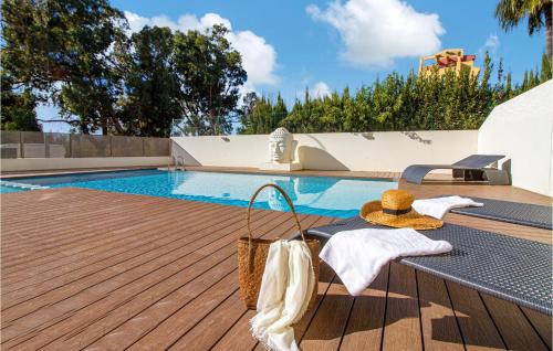 デニアにある3 Bedroom Awesome Apartment In Deniaのテーブルとバスケットが横に置かれたプール