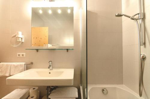 a bathroom with a sink and a shower at Residence Hotel Alpinum in Campo Tures