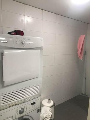 baño pequeño con pared de azulejos blancos en Valoisa avara yksiö loistavalla sijannilla, en Rauma