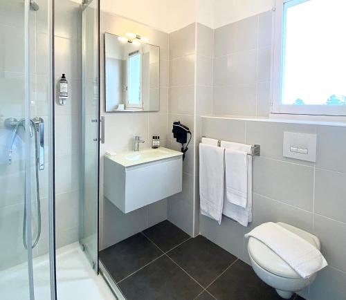 a bathroom with a toilet and a sink and a shower at Hotel Les Pavillons Du Golfe in Favone