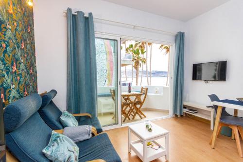 ラスパルマス・デ・グランカナリアにあるAzul Apartmentのリビングルーム(青いソファ、テーブル付)