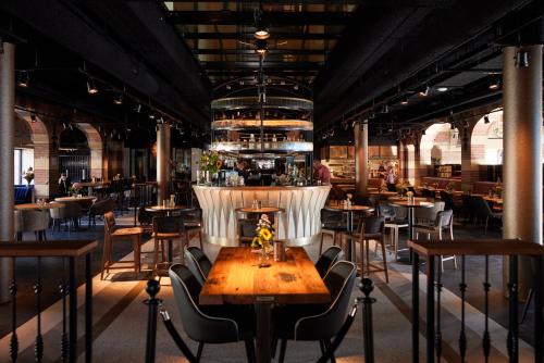 a restaurant with a table and chairs and a bar at Heavens Hotel in Hoorn
