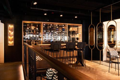 a restaurant with a bar with chairs and tables at Heavens Hotel in Hoorn