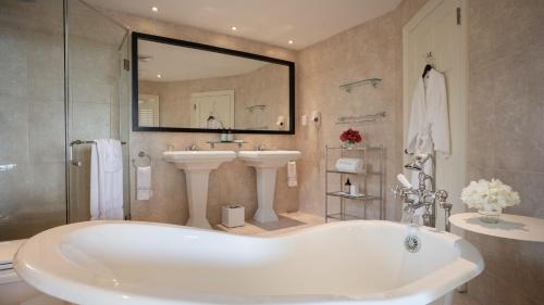 y baño con bañera, lavabo y espejo. en Blue Waters Resort and Spa en Saint John