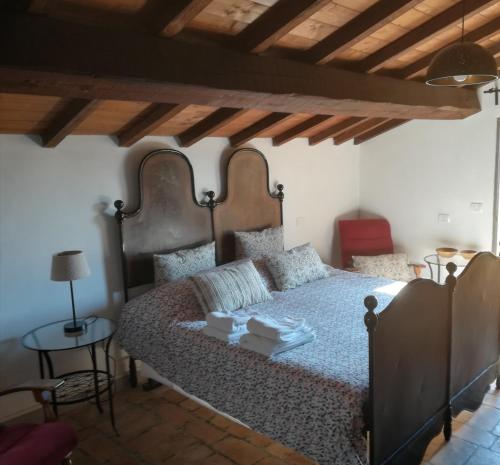 ein Schlafzimmer mit einem großen Bett und einer Holzdecke in der Unterkunft Antico Gioiello Umbro , appartamento con terrazza in Foligno