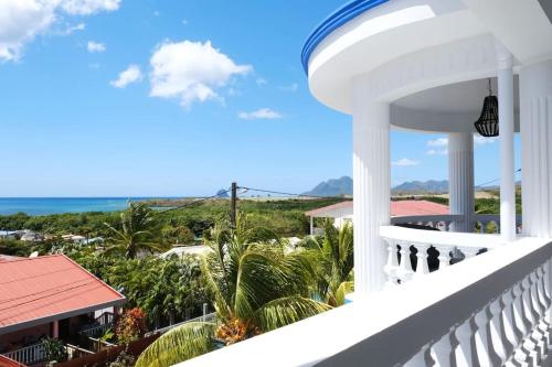 a balcony of a house with a view of the ocean at Villa Beauregard in Sainte-Luce